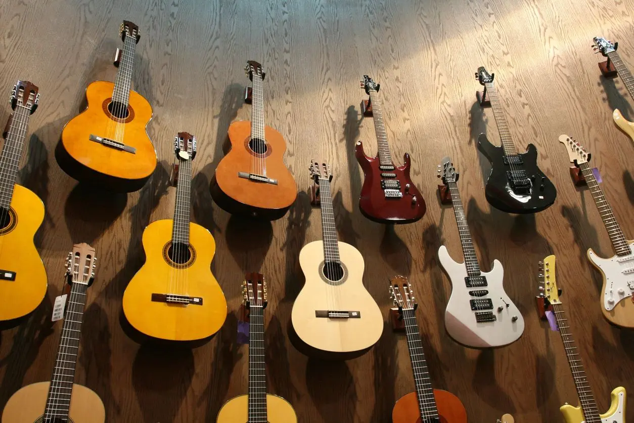A group of guitars sitting on top of a wooden table.